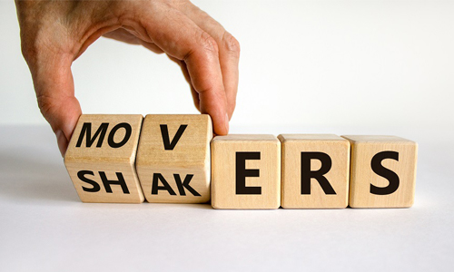 Movers and Shakers symbol. Businessman hand turns cubes and changes the word 'shakers' to 'movers'.