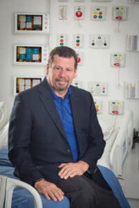 Ray Bailey, founder and president of Lone Star Communications sitting on hospital bed