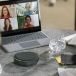 Person using Jabra Speak2 speakerphone.