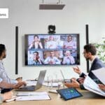 People attending a hybrid room meeting in a conference room.