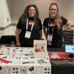 Erica Carroll and Jennifer Goodyer from AV Gives working at InfoComm 2022 Rosie Riveters fundraising campaign.