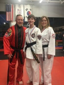 CM Arcemont posing with students at karate facility.