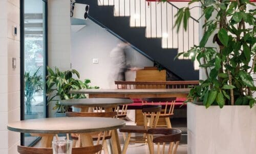 Interior of Fig at Malcha, Delhi. A blurred person is walking around the restaurant tables.