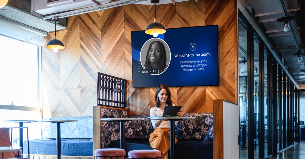 employee working with digital signage behind, Diversified Appspace