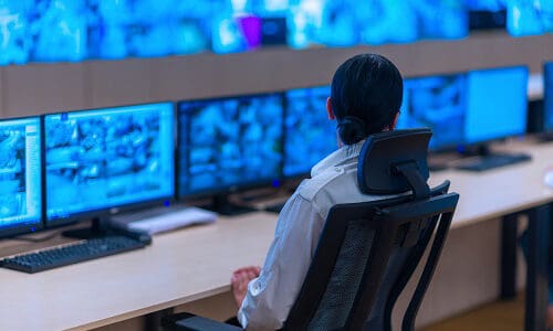Matrox Video's webcast on Disaster Recovery and Control Room Management: IP KVM Trends, Group of Security data center operators (administrators) working in a group at a CCTV monitoring room while looking at multiple monitors ( computer screens)