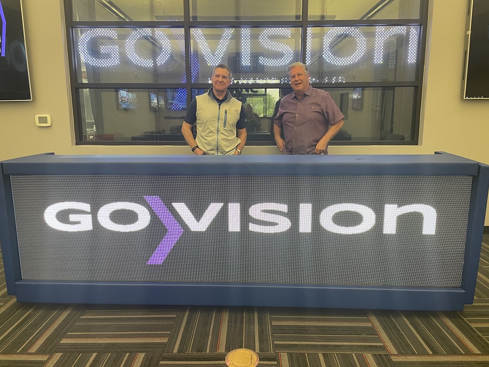 Curtis and Faciane behind GoVision sign.