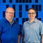 Dr. Paul Henderson and Stephen Siegel standing in front of Fulcrum Immersive backdrop.