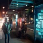 Person walking by a travel digital signage.