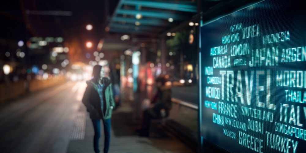 Person walking by a travel digital signage.