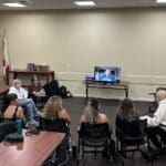 Suicide support group speaking in conference room.