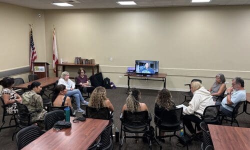 Suicide support group speaking in conference room.