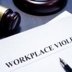 Document that says "workplace violence" with a gavel to depict harassment policies.