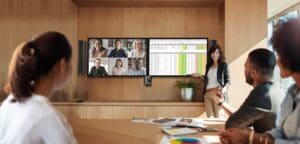 Female coworker making presentation during business meeting in office. Group of creative designers discussing new marketing ideas together in boardroom.