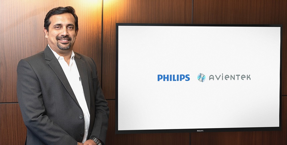 VM Manu, director of Avientek posing next to a poster of PPDS and Avientek.