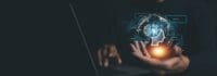 Person on computer with hand outstretched and holding futuristic AI.