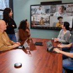 Biamp conferencing technology in a meeting room filled with in-person/remote employees.