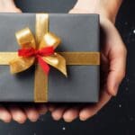 christmas background with hands holding present box background. Beautiful gift box on color background., tech gifts,