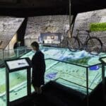 Person interacting with display at First Light Exhibition, Jodrell Bank Observatory.