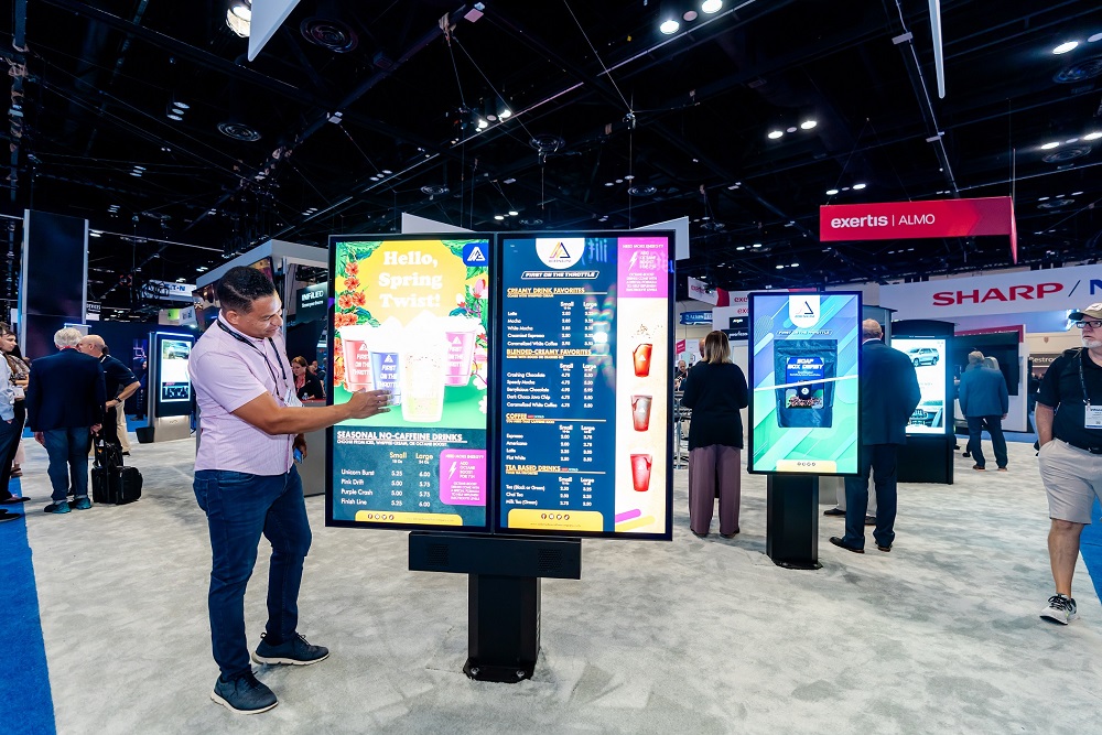 A man pointing at a digital signage menu board at InfoComm Show in Orlando, Florida 2023.