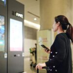 Traveler Interacting with Digital Display at Airport Terminal