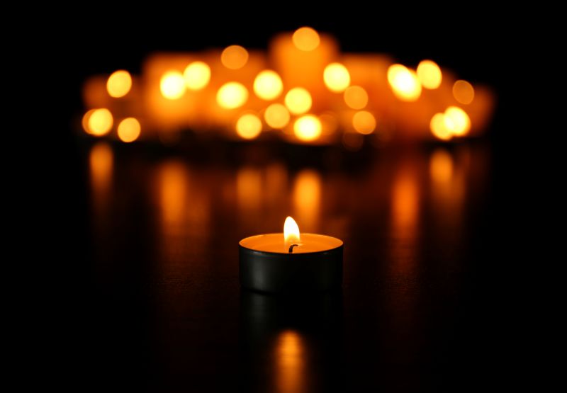 Burning candles on dark background. Africa Studio / stock.adobe.com