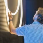 Person examining motion sensor tech at CEDIA Expo/CIX 2025.