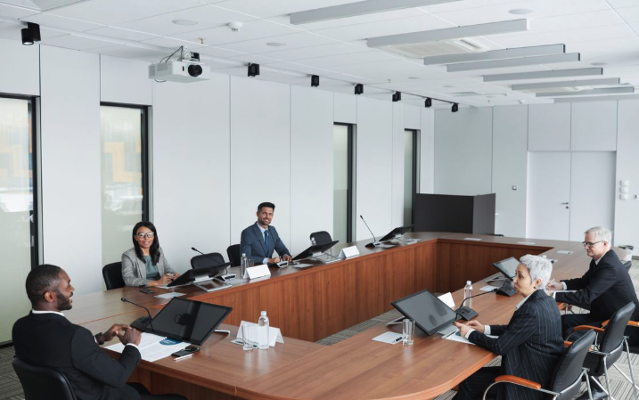 Professionals in a modern conference room with projector and AV equipment