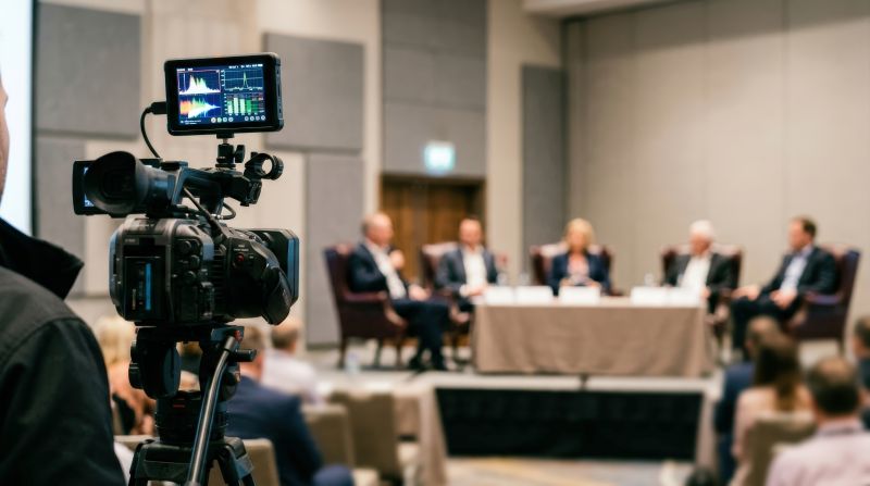 Corporate panel discussion being filmed in conference setting By spyrakot